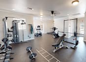 Thumbnail 20 of 35 - A spacious gym with a variety of equipment including a treadmill, elliptical machines, and weightlifting machines.