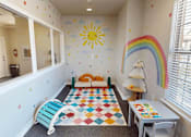 Thumbnail 18 of 35 - A child's playroom with a rainbow, sun, and a checkerboard rug.