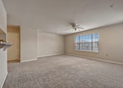 Thumbnail 9 of 35 - A spacious room with a ceiling fan and a window.