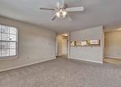 Thumbnail 7 of 35 - A spacious room with a ceiling fan and carpeted floor.
