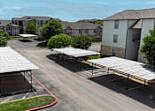 Thumbnail 29 of 35 - A parking lot with a few cars and a building in the background.