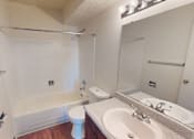 Thumbnail 14 of 26 - A white toilet sits in a bathroom next to a sink and a bathtub.
