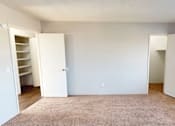 Thumbnail 12 of 26 - A room with a carpeted floor and two open doors.