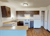 Thumbnail 5 of 26 - A kitchen with wooden cabinets and a white refrigerator.