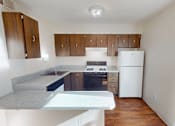 Thumbnail 4 of 26 - A kitchen with white appliances and wooden cabinets.