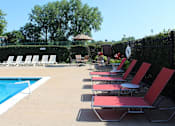 Thumbnail 18 of 26 - a group of red chairs sitting next to a swimming pool