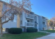 Thumbnail 21 of 22 - an apartment building with a sidewalk and a tree in front of it