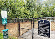 Thumbnail 26 of 36 - A sign that says Dog Park Rules stands in front of a fence.