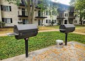 Thumbnail 25 of 36 - Two mailboxes are on a concrete slab with a tree and apartment building in the background.