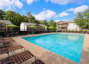 Thumbnail 25 of 32 - a resort style pool with chairs and umbrellas next to a building