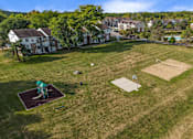 Thumbnail 26 of 31 - A park with a playground and a soccer field.