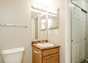 Thumbnail 19 of 31 - A bathroom with a toilet, sink, mirror and light.