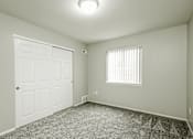 Thumbnail 17 of 31 - A white door is on the left of a room with a window on the right.