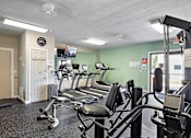 Thumbnail 20 of 31 - A gym with treadmills and exercise equipment.