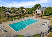 Thumbnail 24 of 31 - An aerial view of a pool surrounded by chairs and trees.