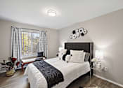 Thumbnail 8 of 31 - A bedroom with a large bed and a window with curtains.