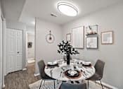 Thumbnail 7 of 31 - A dining room with a round table set for a meal.