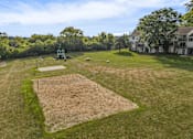 Thumbnail 25 of 31 - A grass field with a volleyball court in the center