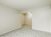Thumbnail 14 of 31 - A large empty room with a carpeted floor and white walls.