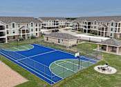 Thumbnail 28 of 35 - A basketball court surrounded by apartment buildings.