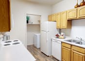 Thumbnail 11 of 35 - A kitchen with a white stove top and wooden cabinets.
