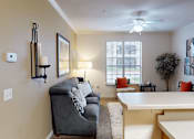 Thumbnail 7 of 35 - A living room with a grey couch and a white table.