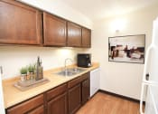 Thumbnail 1 of 22 - a kitchen with wooden cabinets and a sink