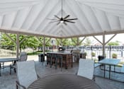 Thumbnail 22 of 33 - a patio with a table and chairs and a grill