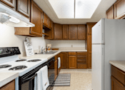 Thumbnail 4 of 8 - A kitchen with wooden cabinets and a white refrigerator.