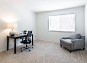 Thumbnail 8 of 8 - A room with a desk, chair, and a sofa.
