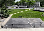 Thumbnail 24 of 39 - A basketball court is surrounded by a black fence.