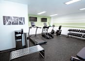 Thumbnail 15 of 29 - A gym with treadmills, weights and exercise equipment.