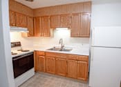 Thumbnail 7 of 29 - A kitchen with wooden cabinets and a white refrigerator.