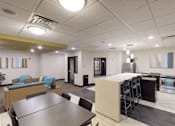 Thumbnail 10 of 14 - A community room with seating and kitchen