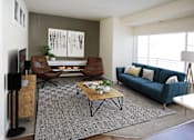 Thumbnail 3 of 14 - A living room with a blue couch and a fireplace.