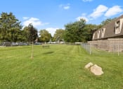 Thumbnail 12 of 25 - a fenced in dog park with apartments in the background