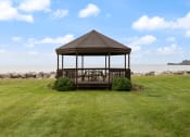 Thumbnail 13 of 25 - a gazebo with a table and chairs on a lawn near the water
