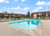 Thumbnail 11 of 25 - a swimming pool in front of an apartment building