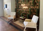 Thumbnail 9 of 30 - a seating area with two chairs and a sign on the wall