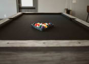 Thumbnail 11 of 30 - a pool table with a bowl of balls on it