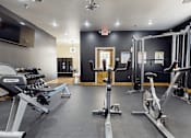 Thumbnail 18 of 29 - A gym with a variety of exercise equipment including treadmills, stationary bikes, and weight machines.