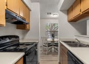Thumbnail 5 of 23 - a kitchen with a stove and a sink and a table