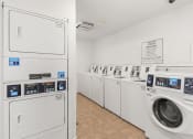 Thumbnail 17 of 23 - a row of washers and dryers in a laundry room with washer machines