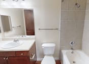 Thumbnail 14 of 32 - A white toilet sits next to a white sink in a bathroom.
