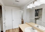 Thumbnail 15 of 32 - A bathroom with a sink, mirror, and lighting fixture.