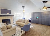 Thumbnail 11 of 30 - A living room with a fireplace, two couches, and a television.