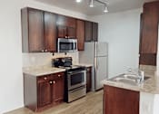 Thumbnail 1 of 32 - A kitchen with brown cabinets and stainless steel appliances.