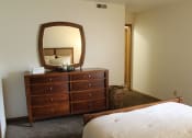 Thumbnail 14 of 35 - a bedroom with a dresser and a bed