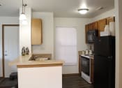 Thumbnail 9 of 35 - a kitchen with a black refrigerator freezer next to a stove top oven