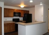 Thumbnail 7 of 35 - apartment kitchen with a black stove top oven next to a black refrigerator